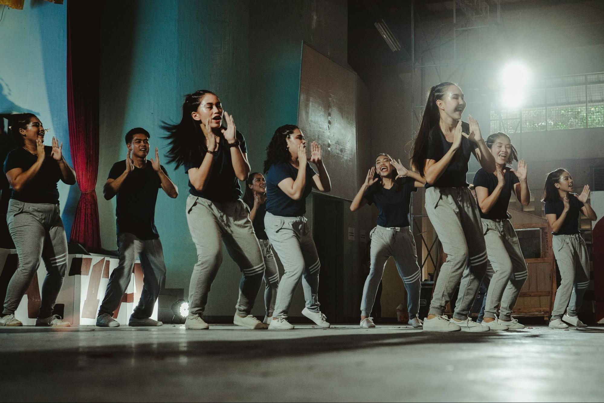 Dance partners rehearsing Cumbia footwork and partner connection in a bright studio