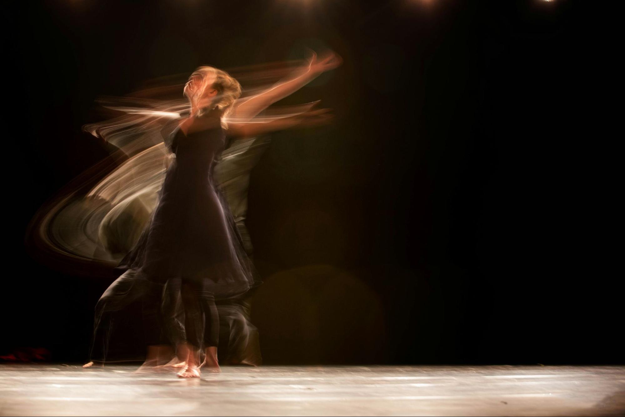 Couple enjoying Cumbia social dancing with expressive movements and stage lighting