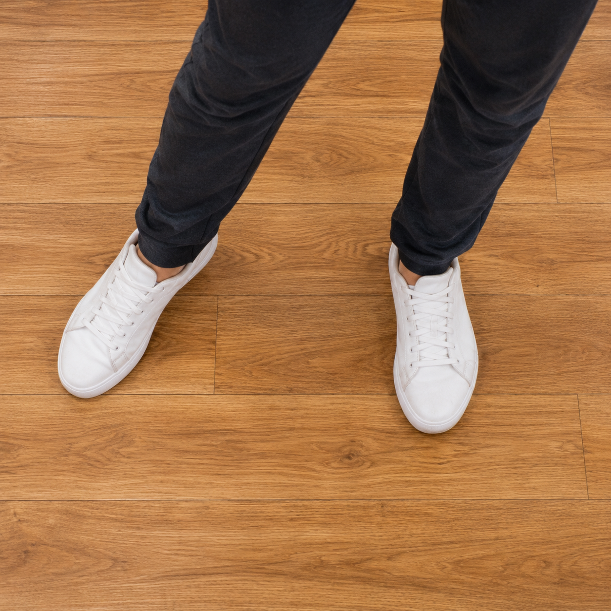 Close-up of a dancer's feet showing the four-count Bachata side step pattern on a hardwood studio floor