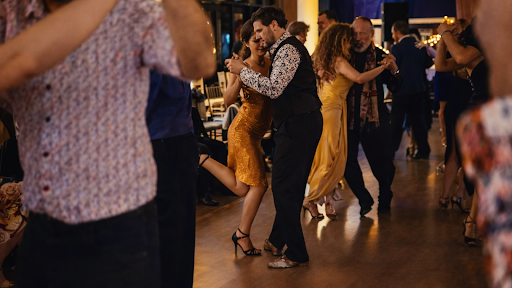 Couples dance happily together under soft lights at a party.