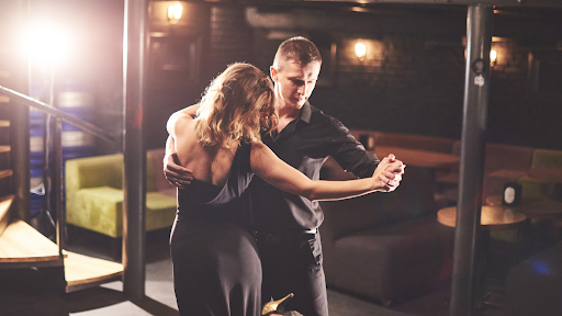A couple dancing closely, with a detailed view of their dance steps on the floor.